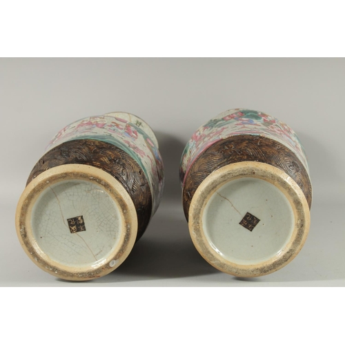 201 - A LARGE PAIR OF CHINESE FAMILLE ROSE PORCELAIN VASES, with moulded twin handles, each painted with a... 