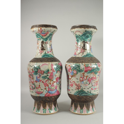 201 - A LARGE PAIR OF CHINESE FAMILLE ROSE PORCELAIN VASES, with moulded twin handles, each painted with a... 