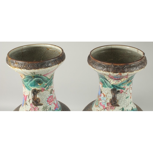 201 - A LARGE PAIR OF CHINESE FAMILLE ROSE PORCELAIN VASES, with moulded twin handles, each painted with a... 