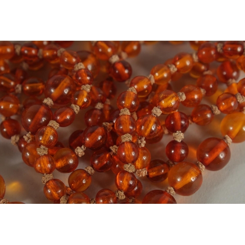 239 - A STRING OF CHINESE AMBER BEADS.