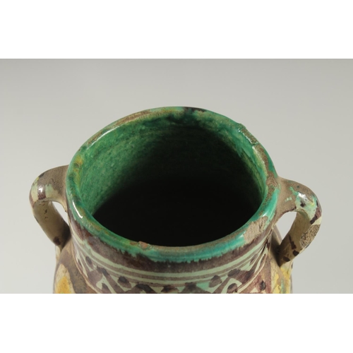 254 - AN 18TH CENTURY MOROCCAN OR TUNISIAN (QALLALIN) POTTERY TWIN HANDLED VASE, 18cm high.