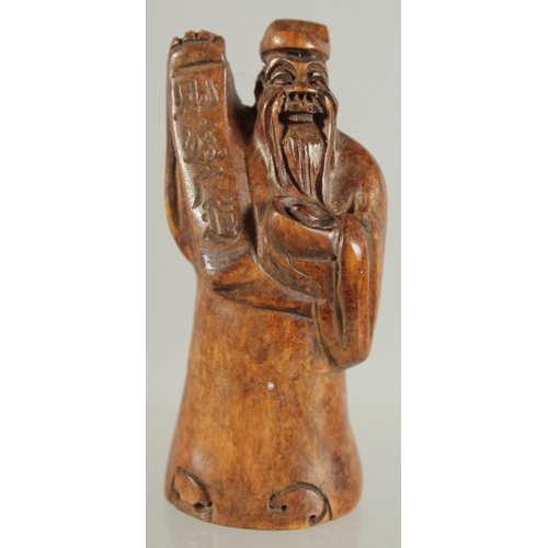 27 - A CHINESE CARVED WOOD FIGURE OF A SAGE, 8.5cm high.