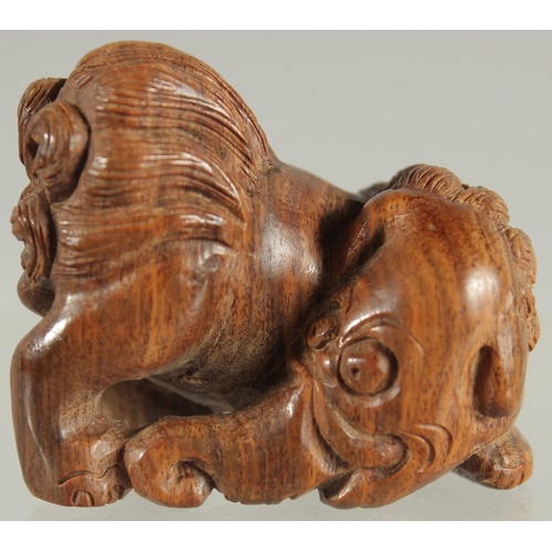 28 - A CHINESE CARVED WOOD NETSUKE OF A BEAST, 4cm wide.