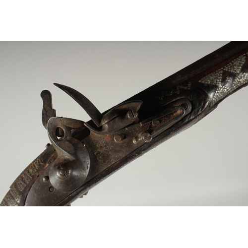 292 - AN OTTOMAN SILVER INLAID FLINTLOCK PISTOL, 43cm.