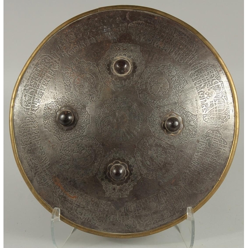 306 - AN ISLAMIC ENGRAVED STEEL SHIELD, with four raised bosses, engraved with foliate panels containing p... 