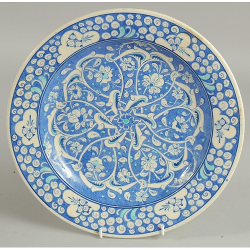 308 - A TURKISH KUTAHYA GLAZED POTTERY PLATE, painted with interlocking foliate design, 32cm diameter.