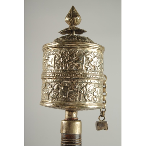 312 - A TIBETAN EMBOSSED SILVER PRAYER WHEEL CONTAINING SCROLL, 27cm long.