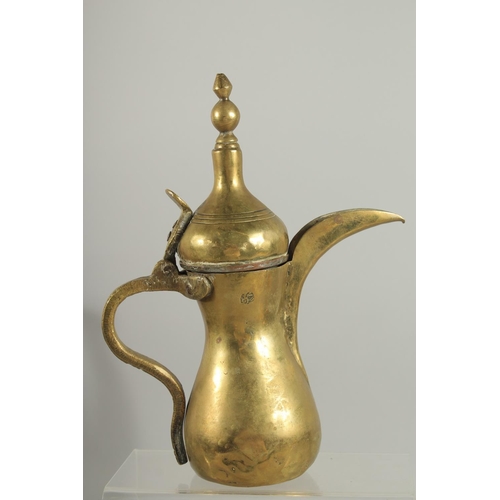 315 - A STAMPED ISLAMIC BRASS COFFEE POT, 27cm high.