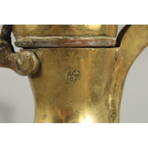 315 - A STAMPED ISLAMIC BRASS COFFEE POT, 27cm high.