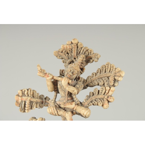 349 - A FINE 17TH-18TH CENTURY SOUTH INDIAN CARVED BONE FLUTING KRISHNA UNDER TREE, 10.5cm high.