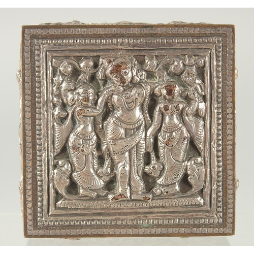 387 - AN INDIAN SILVER OVERLAID SQUARE BOX, with hinged lid and relief decoration, 8cm square.