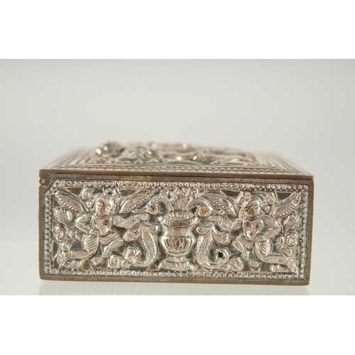 387 - AN INDIAN SILVER OVERLAID SQUARE BOX, with hinged lid and relief decoration, 8cm square.