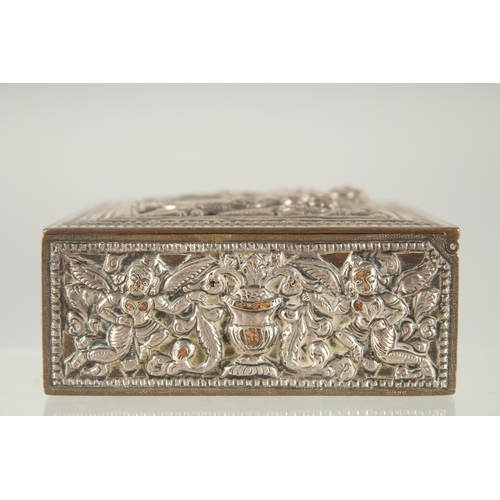 387 - AN INDIAN SILVER OVERLAID SQUARE BOX, with hinged lid and relief decoration, 8cm square.