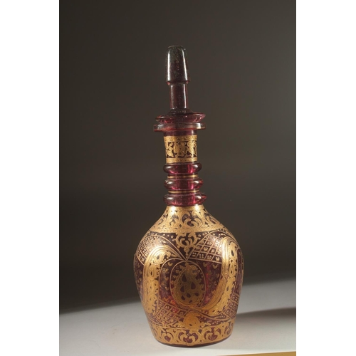 418 - A LARGE BOHEMIAN GLASS BOTTLE AND STOPPER, the body with decorative gilded motifs, 48cm high.