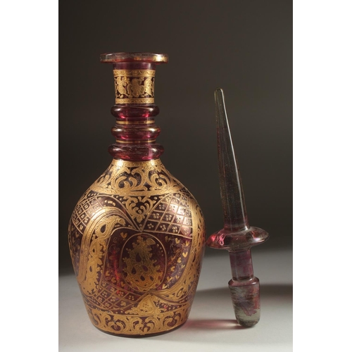 418 - A LARGE BOHEMIAN GLASS BOTTLE AND STOPPER, the body with decorative gilded motifs, 48cm high.