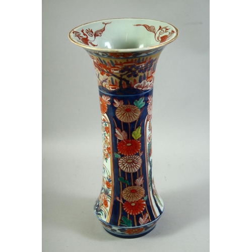 59 - A LARGE JAPANESE IMARI PORCELAIN SLEEVE VASE, painted with a village landscape with panels of flower... 