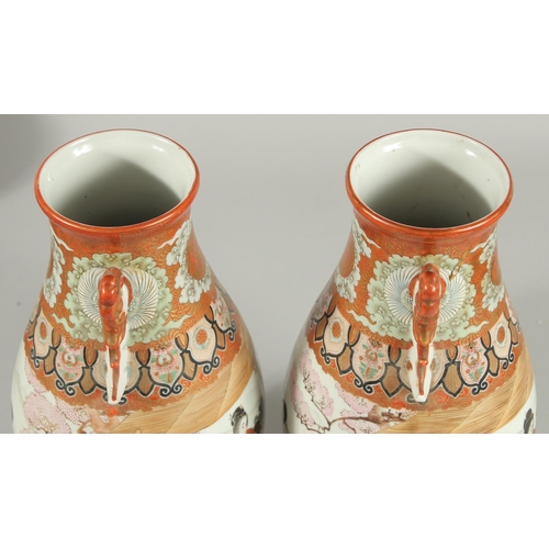 60 - A FINE PAIR OF JAPANESE KUTANI PORCELAIN TWIN HANDLE VASES, painted with a continuous scene depictin... 