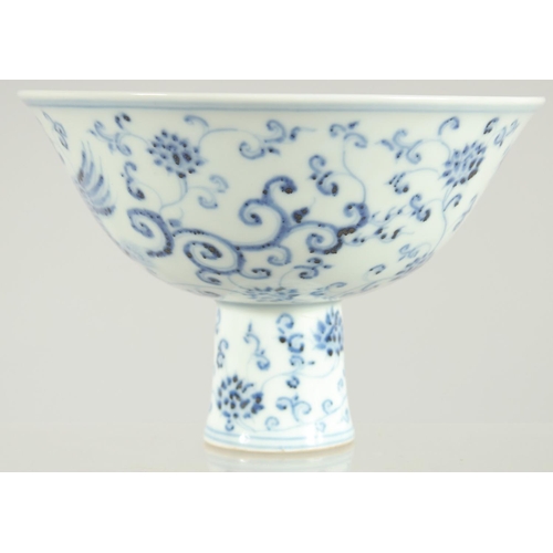 63 - A CHINESE BLUE AND WHITE PORCELAIN STEM BOWL, decorated with phoenix and flora, 17cm diameter.