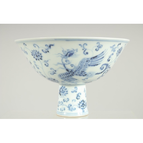 63 - A CHINESE BLUE AND WHITE PORCELAIN STEM BOWL, decorated with phoenix and flora, 17cm diameter.