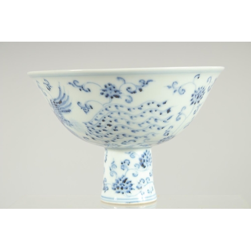 63 - A CHINESE BLUE AND WHITE PORCELAIN STEM BOWL, decorated with phoenix and flora, 17cm diameter.