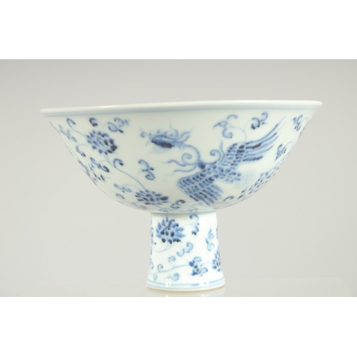 63 - A CHINESE BLUE AND WHITE PORCELAIN STEM BOWL, decorated with phoenix and flora, 17cm diameter.