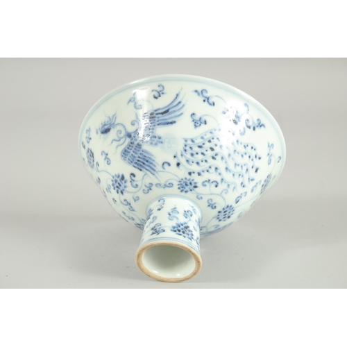 63 - A CHINESE BLUE AND WHITE PORCELAIN STEM BOWL, decorated with phoenix and flora, 17cm diameter.