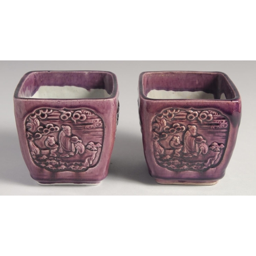 71 - A PAIR OF EARLY 20TH CENTURY CHINESE PURPLE GLAZE FLOWER POTS, with panels of relief decoration and ... 