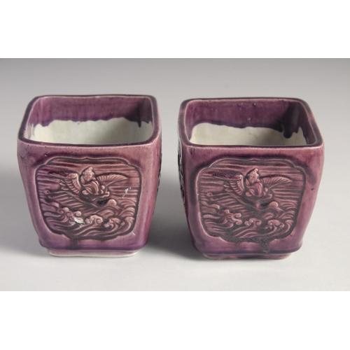 71 - A PAIR OF EARLY 20TH CENTURY CHINESE PURPLE GLAZE FLOWER POTS, with panels of relief decoration and ... 