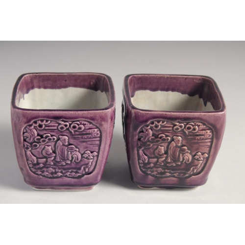 71 - A PAIR OF EARLY 20TH CENTURY CHINESE PURPLE GLAZE FLOWER POTS, with panels of relief decoration and ... 