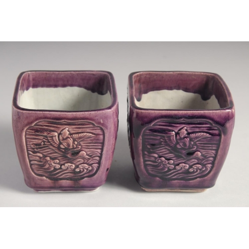 71 - A PAIR OF EARLY 20TH CENTURY CHINESE PURPLE GLAZE FLOWER POTS, with panels of relief decoration and ... 