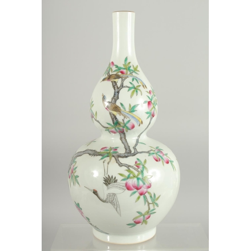 76 - A CHINESE FAMILLE ROSE PORCELAIN DOUBLE GOURD VASE, decorated with cranes and peach blossom, base wi... 