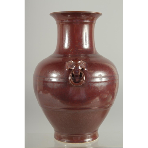 79 - A CHINESE MOTTLED RED GLAZE TWIN HANDLE VASE, with impressed mark to base, 25cm high.