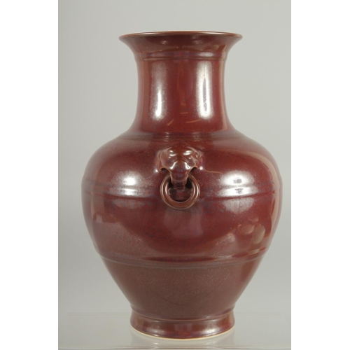 79 - A CHINESE MOTTLED RED GLAZE TWIN HANDLE VASE, with impressed mark to base, 25cm high.