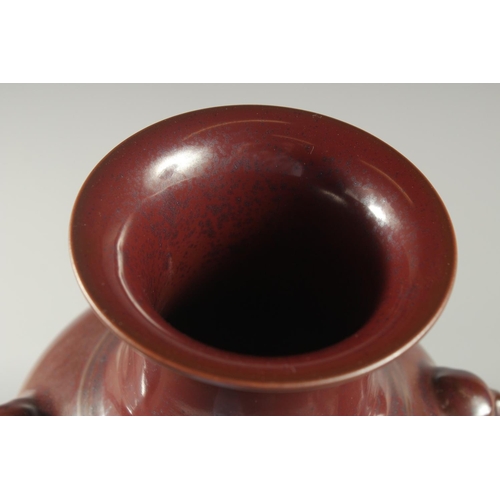 79 - A CHINESE MOTTLED RED GLAZE TWIN HANDLE VASE, with impressed mark to base, 25cm high.