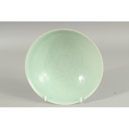 87 - A CHINESE CELADON BOWL, with incised decoration, 20.5cm diameter.