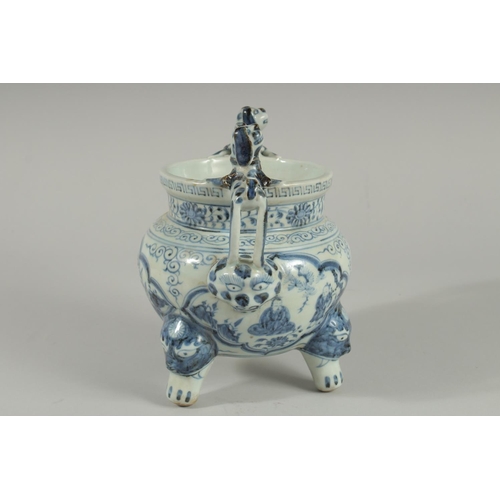 90 - A CHINESE BLUE AND WHITE PORCELAIN TRIPOD CENSER, with moulded dog handles, 20.5cm high.