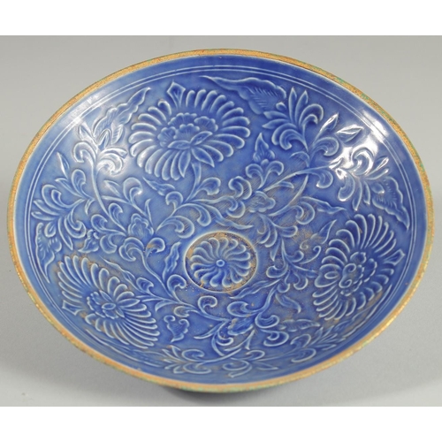 96 - A CHINESE BLUE GROUND CARVED FLORAL BOWL, character mark to base, 20cm diameter.