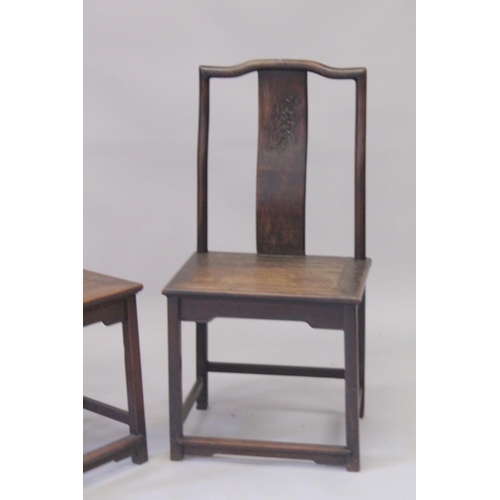 1032 - A PAIR OF CHINESE HARDWOOD CHAIRS with carved panel backs. 3ft 7ins high.