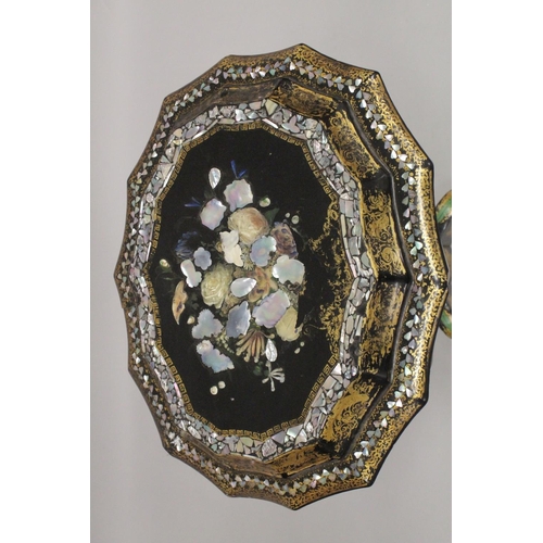 1047 - A VICTORIAN PAPIER MACHE TEA POUY ON A TRIPOD BASE, inlaid with mother of pearl and decorated in gil... 