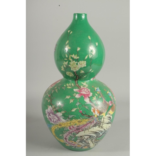 1242 - A CHINESE GREEN PORCELAIN DOUBLE GOURD VASE decorated with flowers. Six-character mark in blue.
