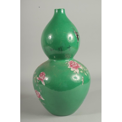 1242 - A CHINESE GREEN PORCELAIN DOUBLE GOURD VASE decorated with flowers. Six-character mark in blue.