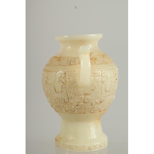 1261 - A CHINESE CARVED WHITE JADE TWO HANDLED VASE. 7ins high.