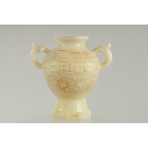 1261 - A CHINESE CARVED WHITE JADE TWO HANDLED VASE. 7ins high.