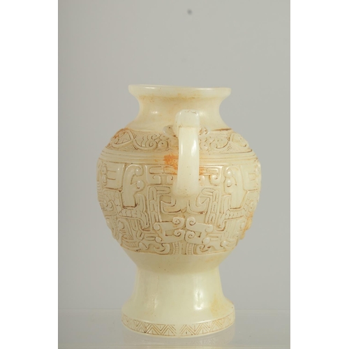 1261 - A CHINESE CARVED WHITE JADE TWO HANDLED VASE. 7ins high.