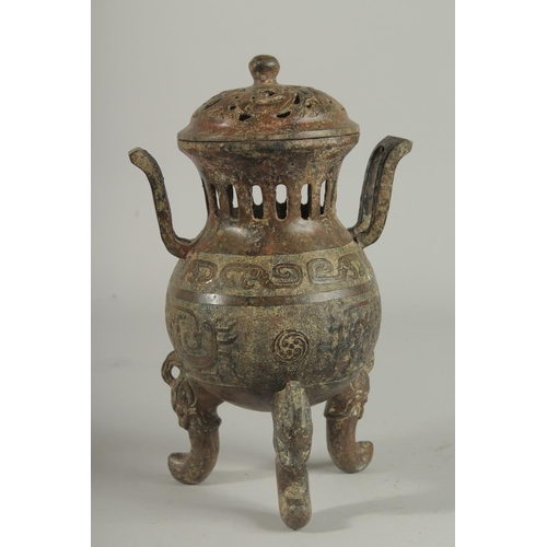 1262 - A CHINESE CARVED TWO HANDLED BRONZE CENSER AND COVER On three curving feet.. 12ins high.