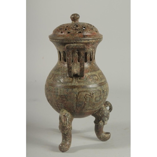 1262 - A CHINESE CARVED TWO HANDLED BRONZE CENSER AND COVER On three curving feet.. 12ins high.