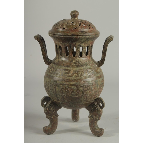 1262 - A CHINESE CARVED TWO HANDLED BRONZE CENSER AND COVER On three curving feet.. 12ins high.