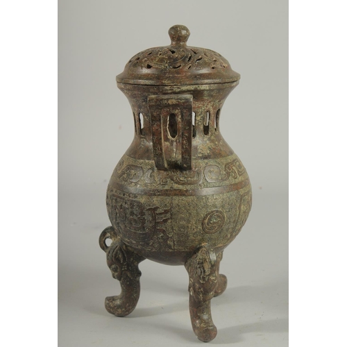 1262 - A CHINESE CARVED TWO HANDLED BRONZE CENSER AND COVER On three curving feet.. 12ins high.