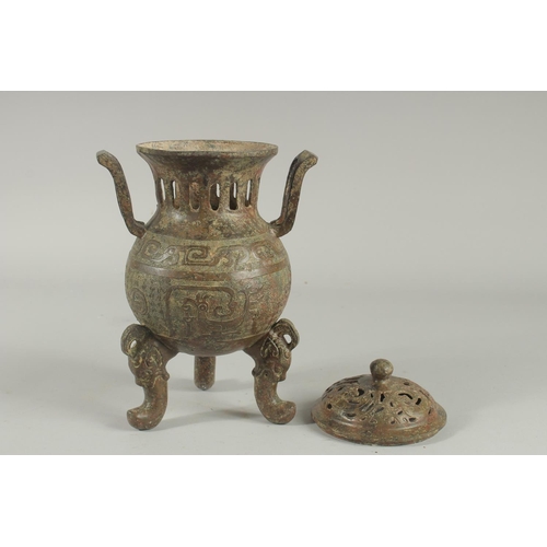 1262 - A CHINESE CARVED TWO HANDLED BRONZE CENSER AND COVER On three curving feet.. 12ins high.