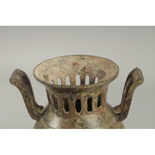 1262 - A CHINESE CARVED TWO HANDLED BRONZE CENSER AND COVER On three curving feet.. 12ins high.